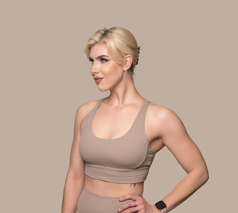 Confident woman in taupe activewear, showcasing wardrobe game-changer.