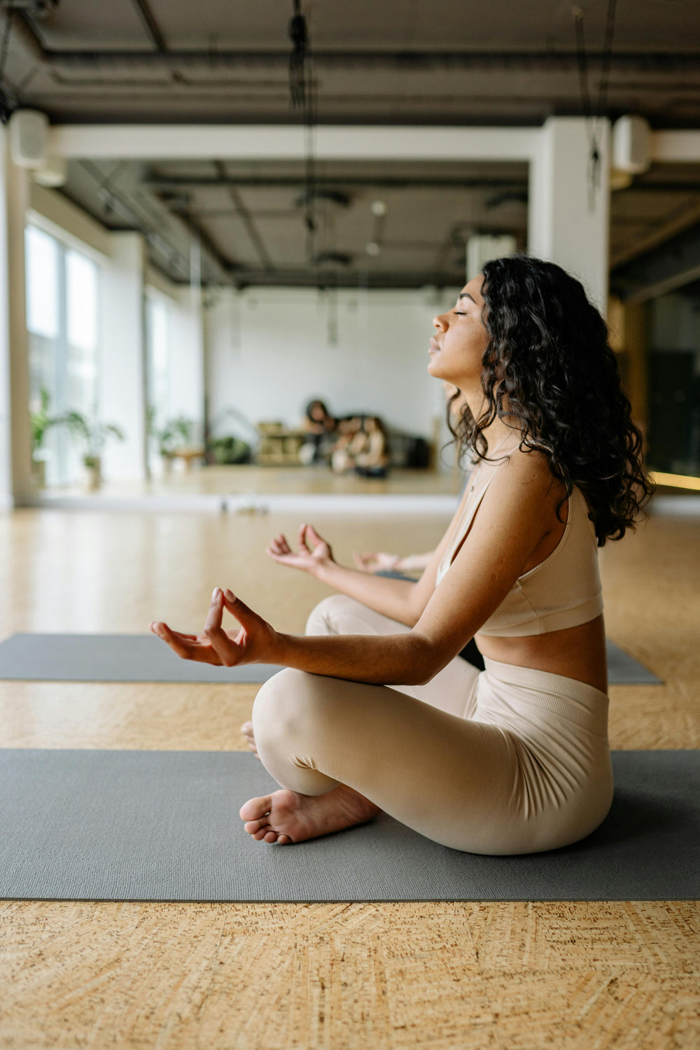 Woman meditating in stylish, comfortable activewear in yoga studio